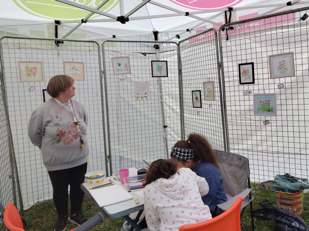 Des grilles d'exposition avec les dessins d'une artiste du quartier